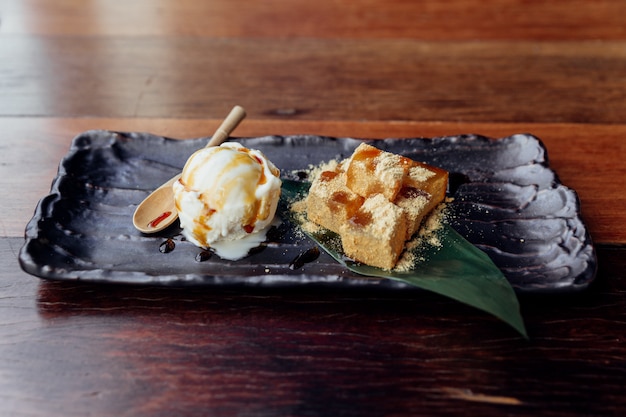 Warabi Mochi servi avec une boule de glace à la vanille garnie de caramel.