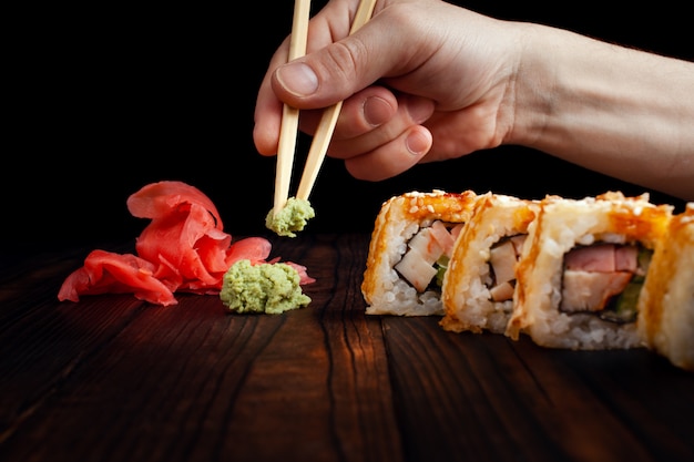 Wasabi, gingembre et rouleaux sur une table en bois.