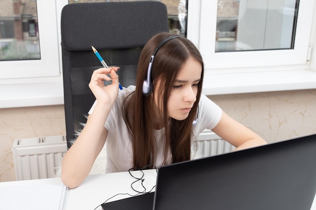 Webinaire en ligne Un étudiant à la maison étudie avec des écouteurs avec un microphone essayant de comprendre le cours