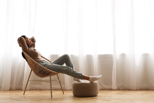 Week-ends enfin fille détendue assise sur une chaise moderne