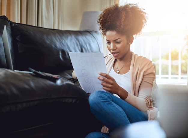 Les week-ends peuvent aussi être productifs Photo d'une jeune femme en train de remplir ses papiers à la maison