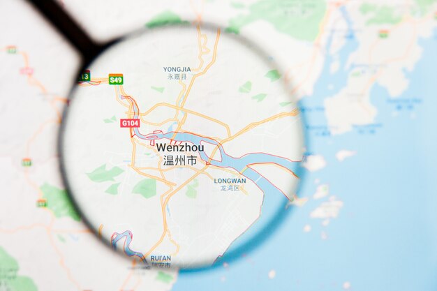 Photo wenzhou, chine concept illustratif de visualisation de la ville sur l'écran d'affichage à travers la loupe
