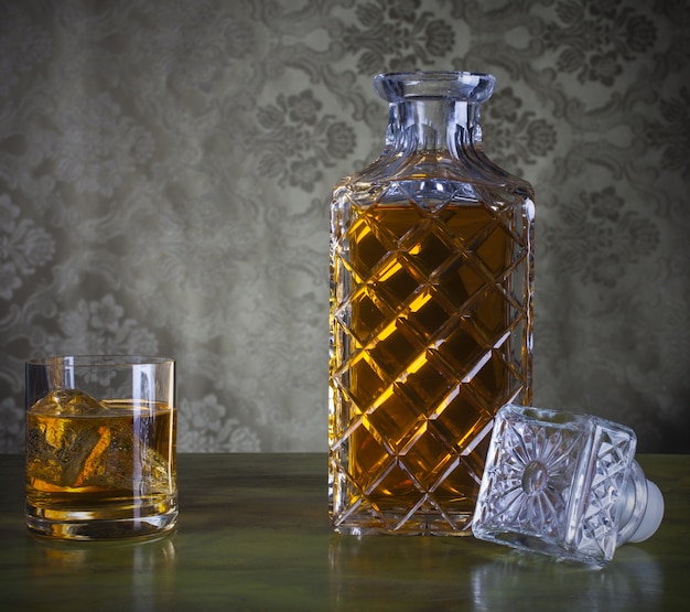 Whisky en bouteille et verre avec glace