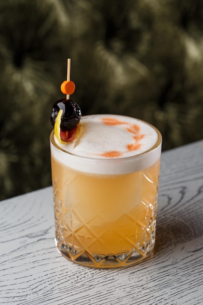 Whisky cocktail pisco sour avec sirop de sucre blanc d'oeuf de citron vert en verre sur fond sombre Espace pour le texte