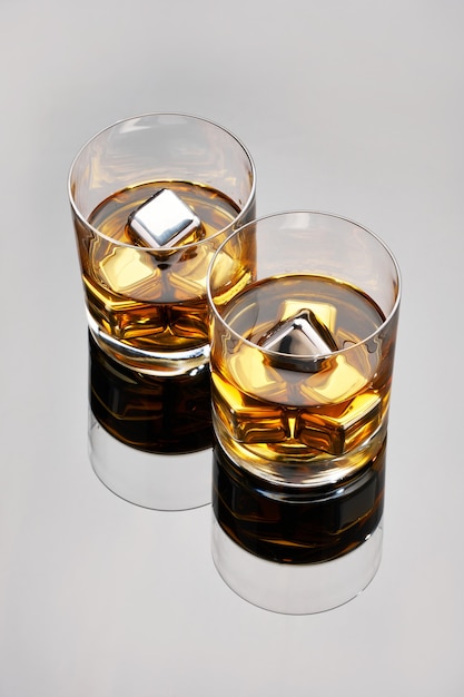 Whisky avec des cubes de refroidissement en acier sur une surface en verre foncé