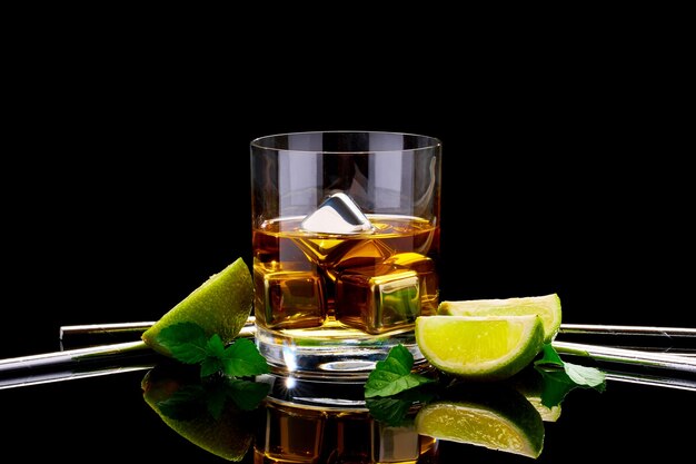 Whisky avec des cubes de refroidissement en acier sur verre sur une surface sombre