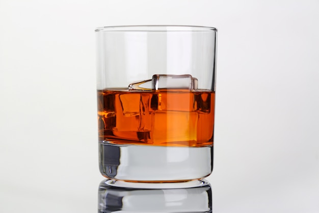 Whisky avec de la glace dans un bécher en verre sur