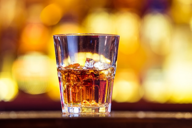 Un whisky avec de la glace dans un verre sur le bar (gros plan). Boisson irlandaise traditionnelle