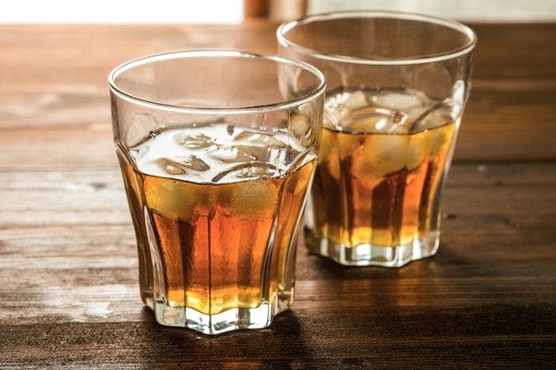 Whisky avec de la glace sur une table en bois