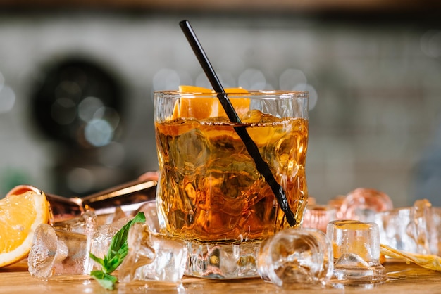 Un whisky avec de la glace en verre sur une table en bois