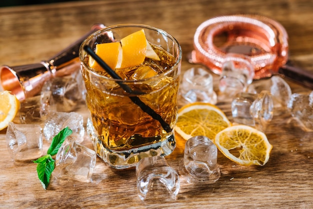 Un whisky avec de la glace en verre sur une table en bois