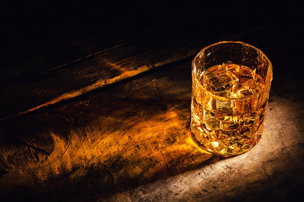 Whisky avec des glaçons sur fond de bois