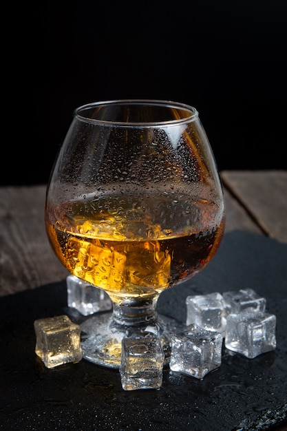 Whisky avec des glaçons sur une table en bois