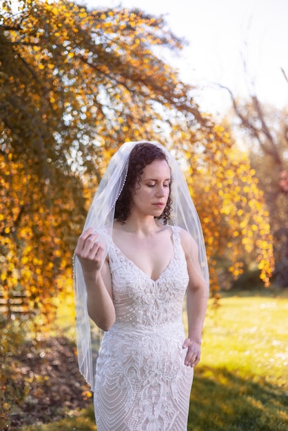 White Caucasian Woman in a Wedding Dress debout à l'extérieur dans la nature