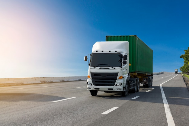 Photo white truck sur route avec conteneur vert, import, transport logistique d'exportation