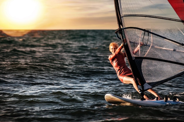 Le windsurf, le plaisir dans l'océan, le sport extrême, le style de vie de la femme.