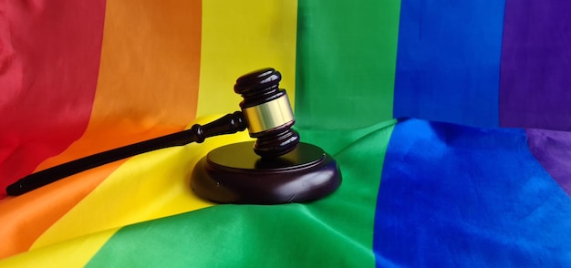 Woden juge gavel symbole du droit et de la justice avec le drapeau lgbt aux couleurs de l'arc-en-ciel sécurité et protection