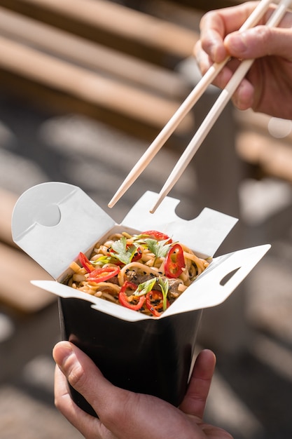 Wok en boîte dans un récipient alimentaire noir