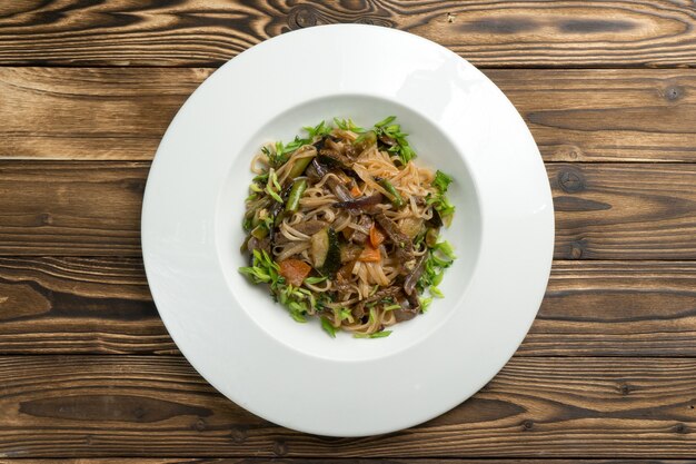 Wok de nouilles de riz chinois au boeuf, légumes et oignons verts.