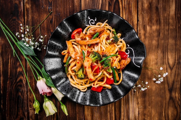 Wok de nouilles udon au poulet et légumes