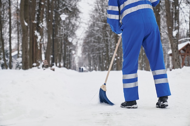 Woker of city service gardant la pelle et brossant le sentier