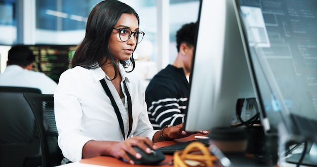 Woman developer and typing on computer in office for programming software update and troubleshooting Person pc and coding for website development testing server and monitor of system application