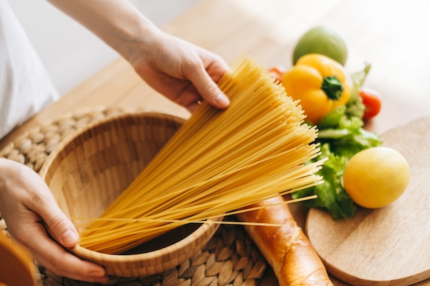 Woman hold spaghetti de blé dans les mains