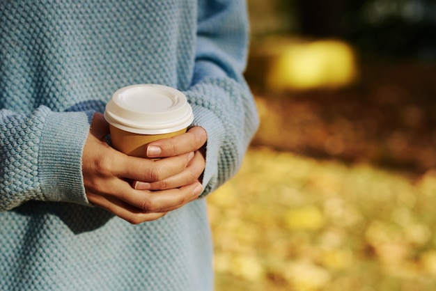 Woman hold tasse de café à emporter en automne park