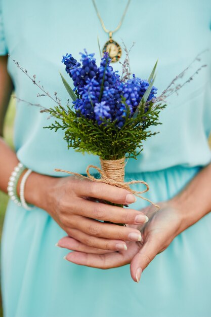 Woman holding bouquet de fleurs bleues