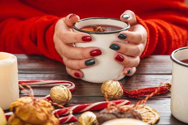 Woman holding cup avec du vin chaud dans ses mains