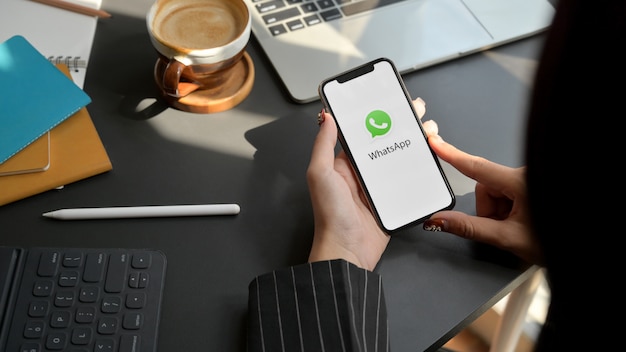 Photo woman holding smartphone with whatsapp app