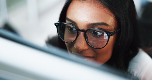 Woman programmer or coding with glasses on computer for software development or web design at office Female person coder or developer with technology for AI programming or UI testing at workplace