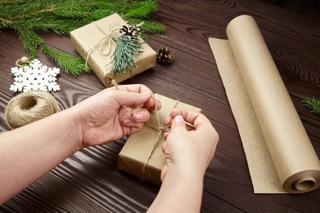 Woman wrapping Christmas cadeaux sur table en bois