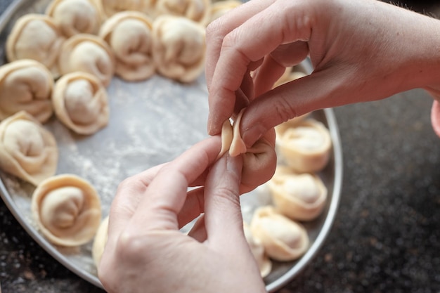 Woman39s mains pâte moulée avec des boulettes de remplissage de viande Cuisson des boulettes maison