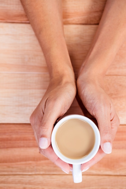 Womans mains tenant une tasse de café