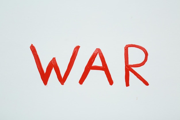 Word War écrit avec de la peinture rouge sur la vue de dessus de fond blanc