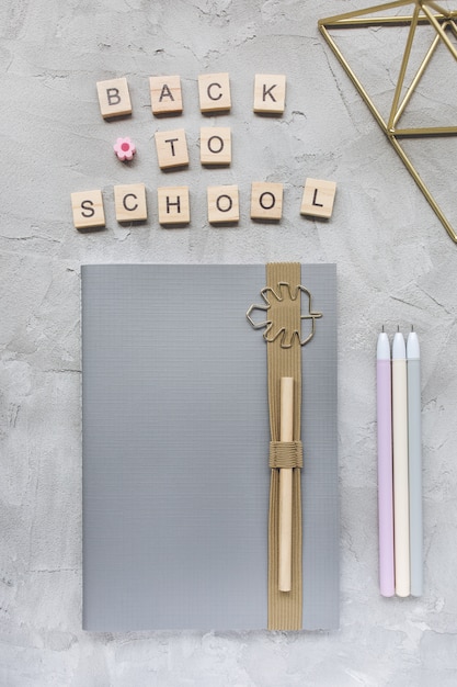 Words BACK TO SCHOOL, cahier et stylos sur gris