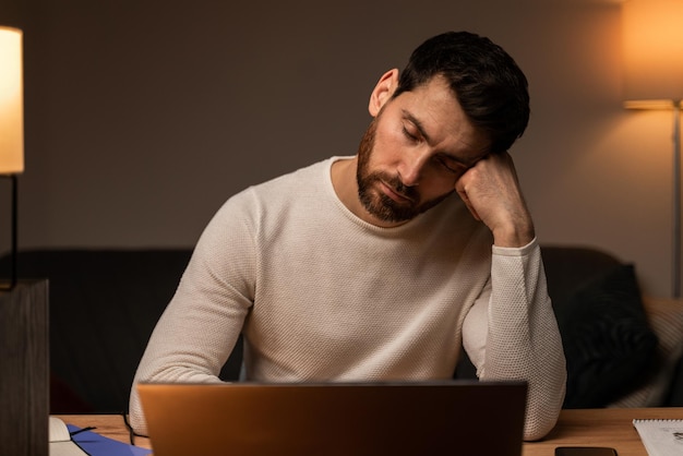 Workaholism, travaillant sur ordinateur portable. Homme d'affaires stressé fatigué ayant une dépression de fatigue, des problèmes d'emploi, des maux de tête et des migraines