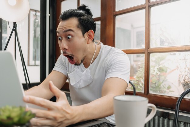 Wow et visage surpris de l'homme travaille avec son ordinateur portable et réussit