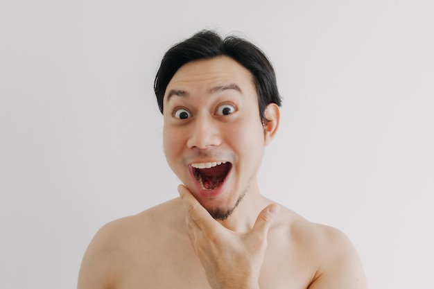 Wow et visage surprise de l'homme utilisant un produit de soin de la peau sur son visage