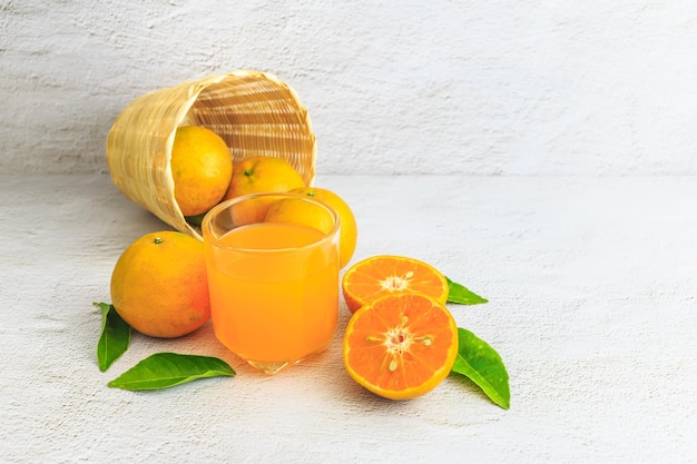 XUn jus d'orange frais avec des fruits orange dans le panier