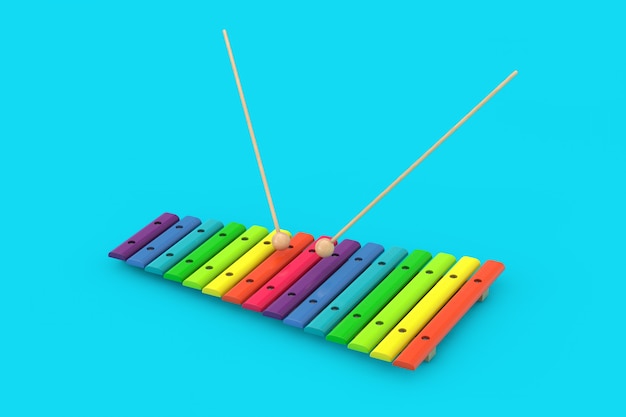 Xylophone en bois coloré avec maillets sur fond bleu. Rendu 3D