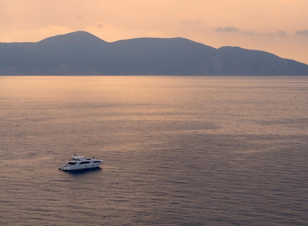 Yacht au coucher du soleil sur l'île de Céphalonie dans la mer Ionienne en Grèce