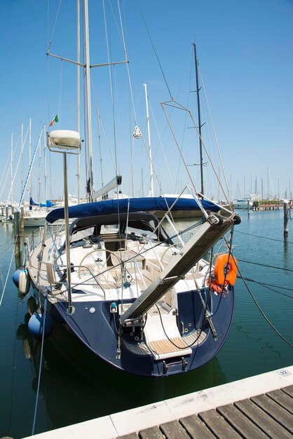 Un yacht bleu dans le port attend La mer est calme