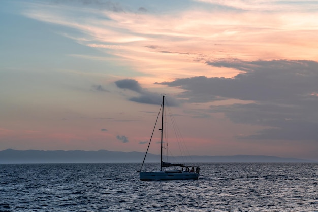 Yacht naviguant contre le coucher du soleil Paysage de style de vie de vacances avec silhouette de voilier et de coucher de soleil