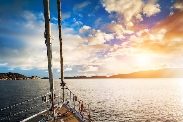 Yacht naviguant entre les îles de la mer au coucher du soleil. Groenland occidental