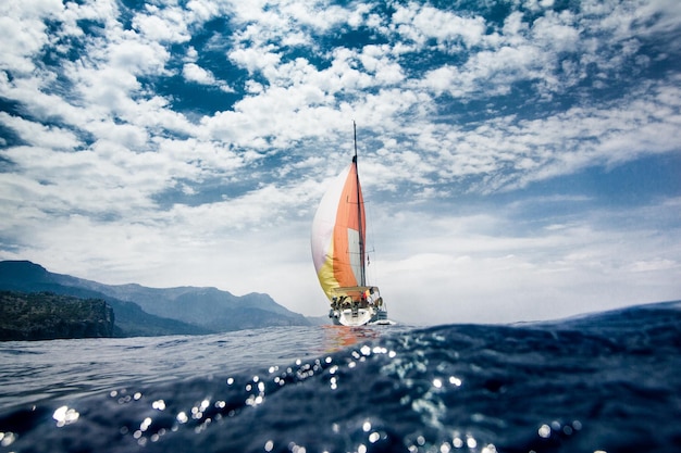 Yacht naviguant sur la mer contre un ciel nuageux