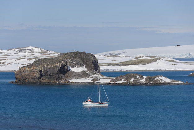 Yacht à voile et iceberg en mer antarctique