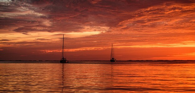 Yachting et voyage Bateau sur la mer de l'océan au coucher du soleil Voiliers à voiles