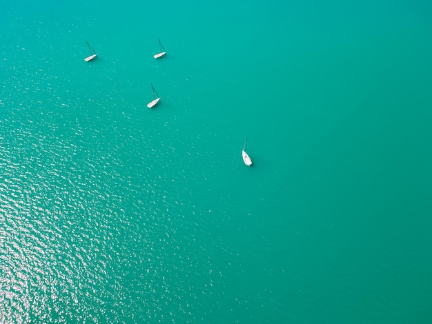 Yachts blancs naviguant dans la mer Surface de l'eau turquoise Vue aérienne de haut en bas Fond d'été